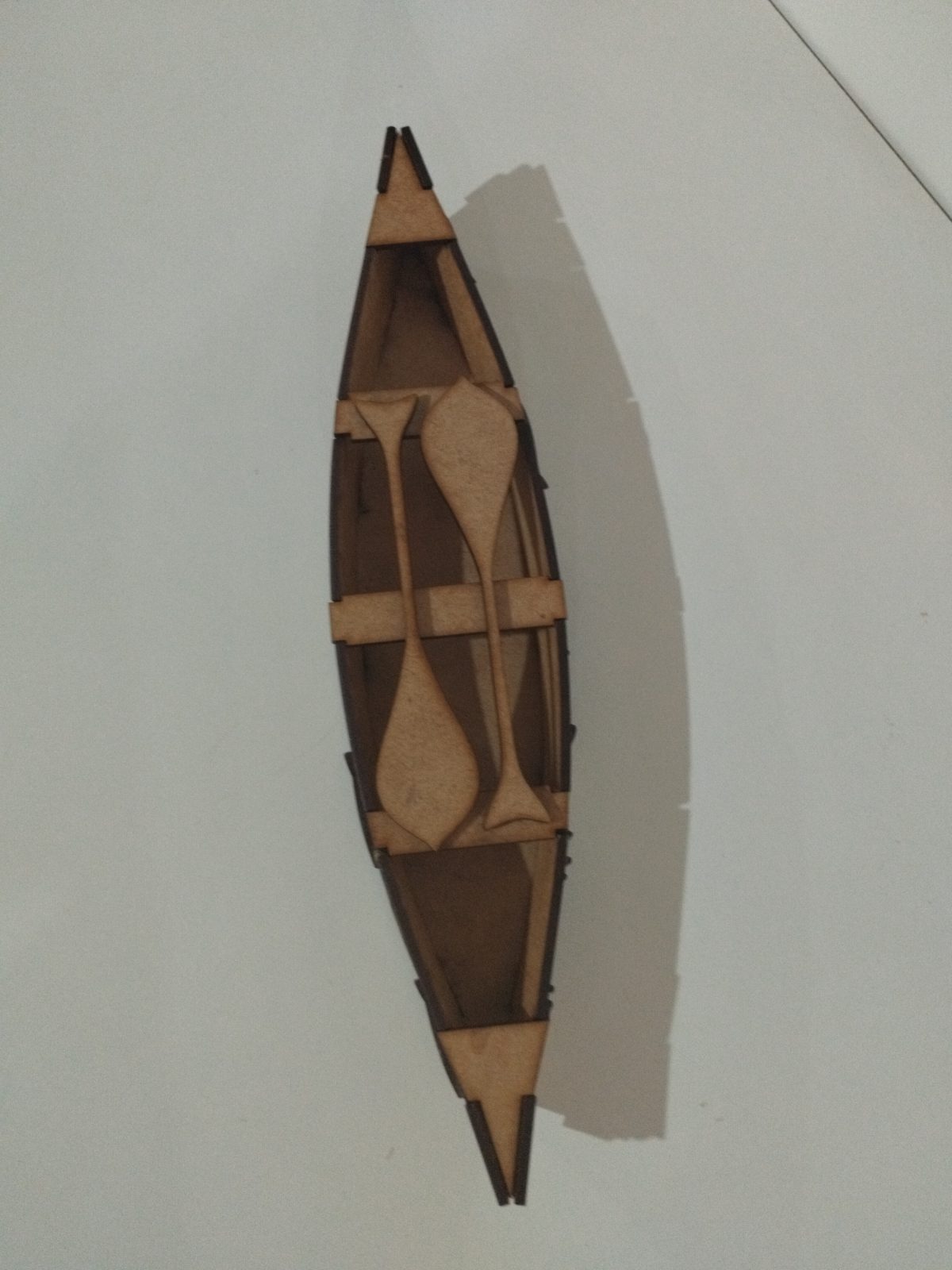 Canoa decorativa de MDF cru vista de cima, com dois remos sobre os bancos