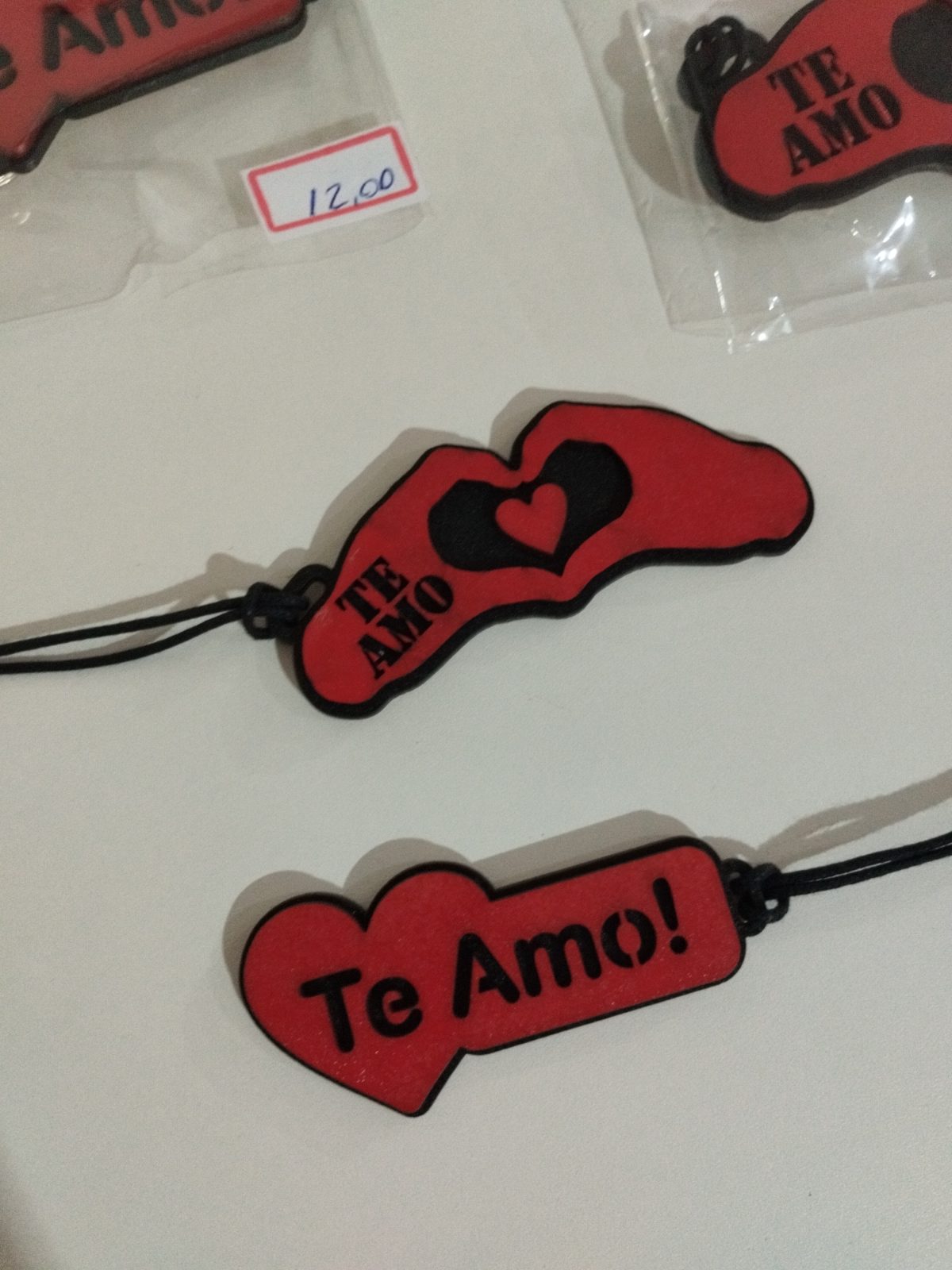 Chaveiros de madeira pintada vermelha com detalhe de coração, mãos e frases de amor