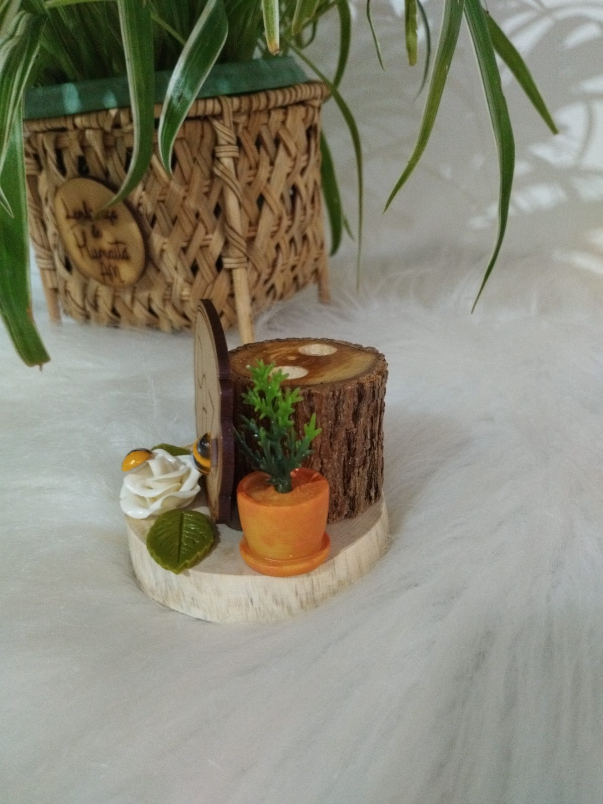 Porta-canetas de madeira com plaquinha Paz visto de lado, tronco, vaso, flor branca e folhas