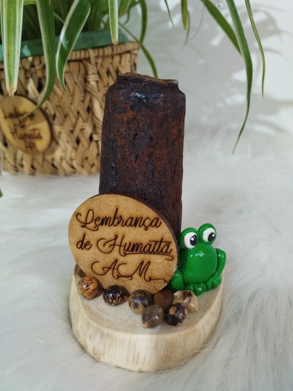 Porta-canetas de tronco de madeira com um sapo verde de biscuit na base