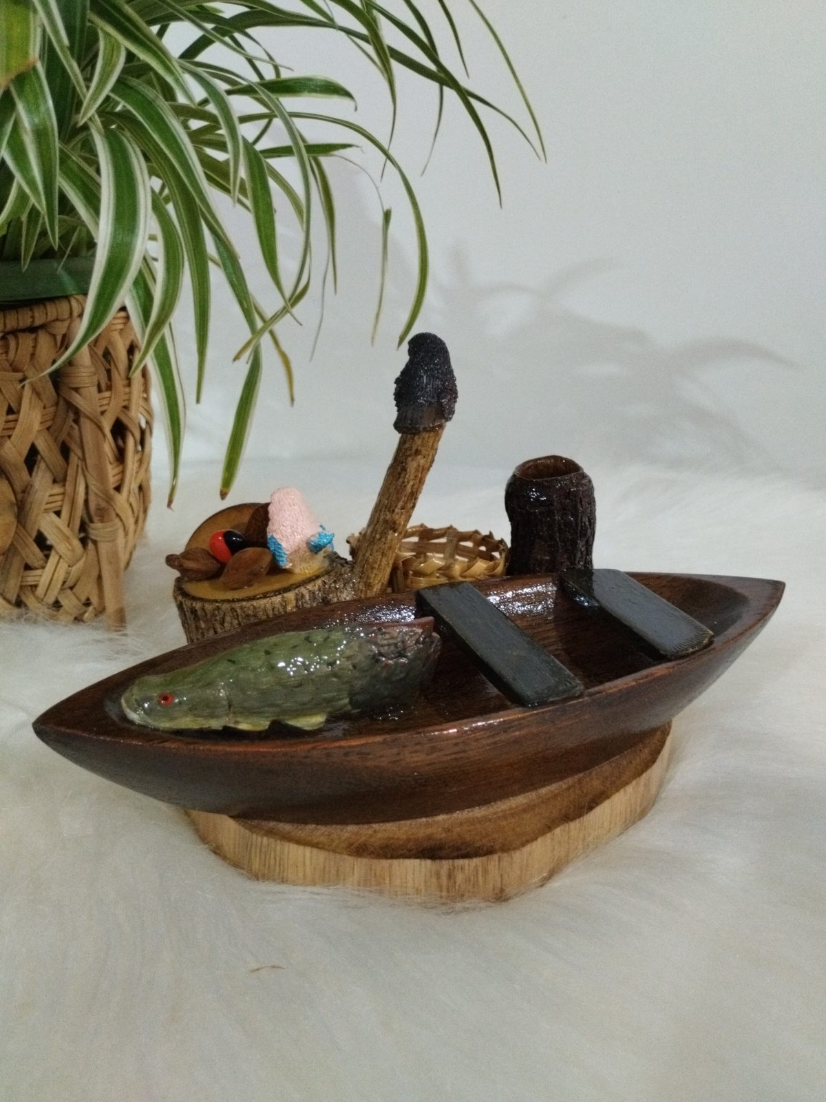 Miniatura de canoa em madeira com peixe verde, pássaros e remos pretos