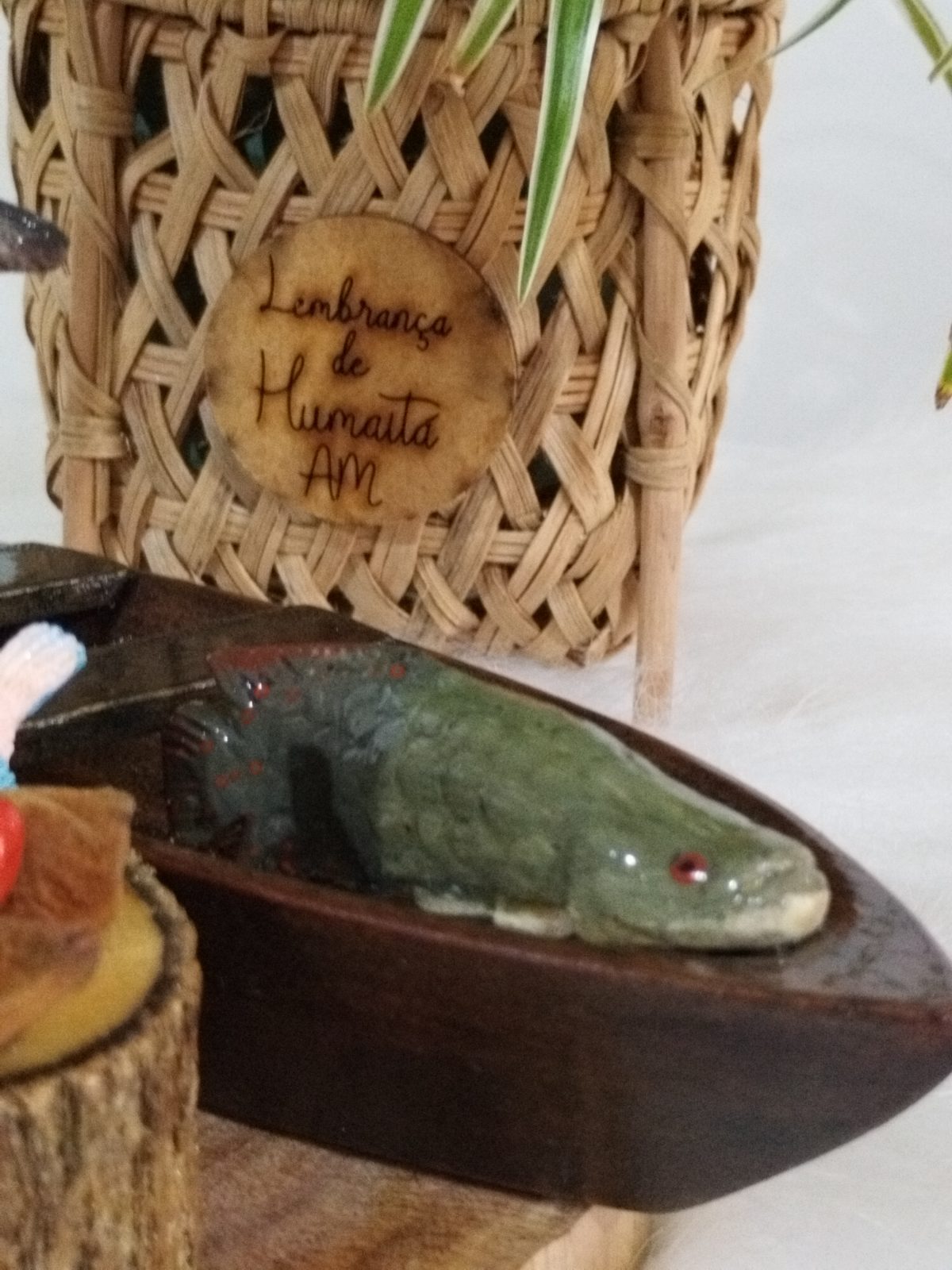 Miniatura de canoa em madeira com detalhe do peixe verde pintado