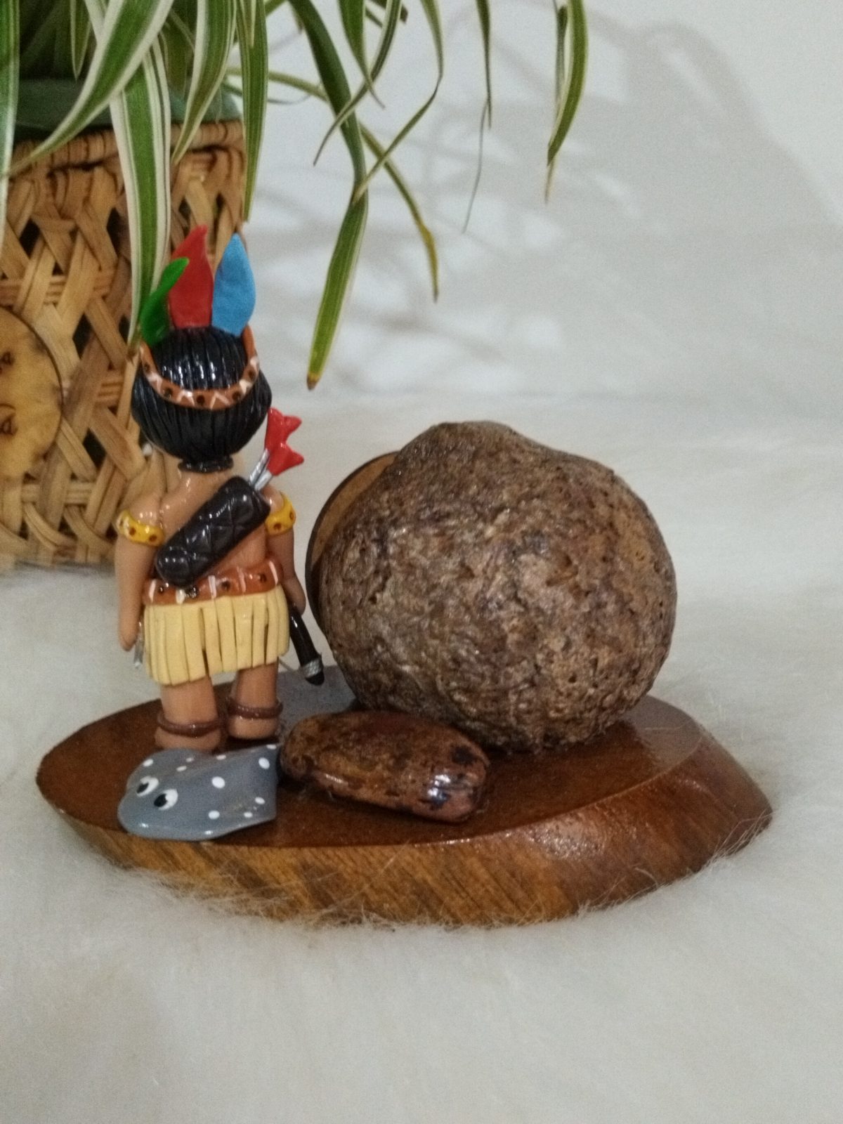 Peça decorativa com verso da miniatura indígena, aljava, arco e grande esfera natural