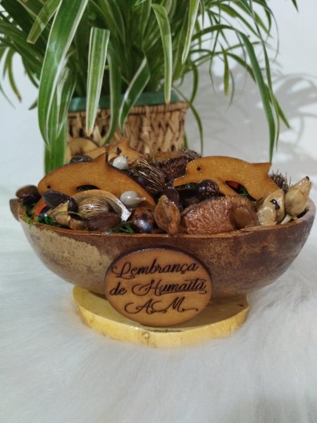 Cuia decorada com sementes e dois golfinhos de madeira, com placa gravada na frente